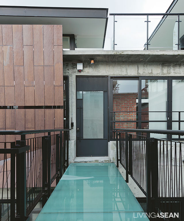 For a lightweight look, concrete flooring on the footbridge is replaced by thick tempered glass panels. 