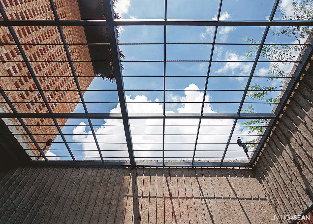 Connecting with nature. A part of the house is left unroofed to bring the big blue sky and the sound of leaves rustling in the trees into the room. 