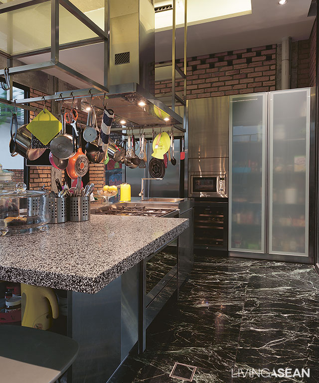 The kitchen is located near living spaces for convenience. The floor is covered in smooth marble, while exposed brick walls add visual interest to loft ideas.