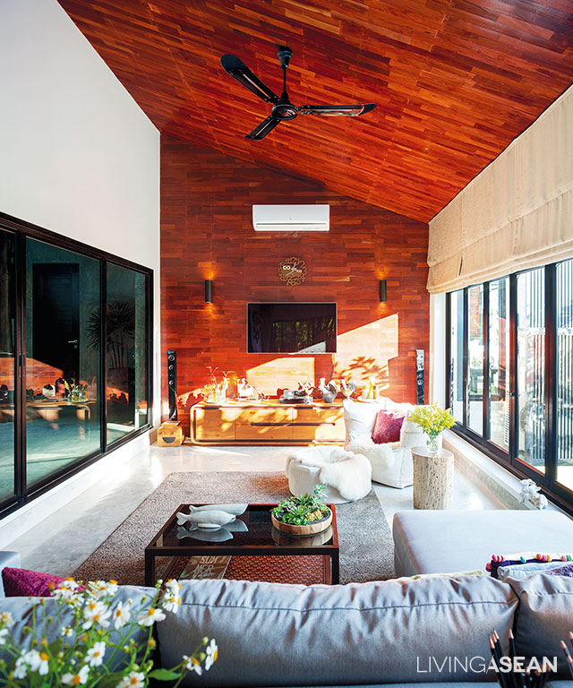 The relaxed atmosphere of a sitting room where timeless elegance meets modern flair. Overhead, the sloped ceiling in vibrant shades of reddish-browns is slanted to match the shape of the roof.