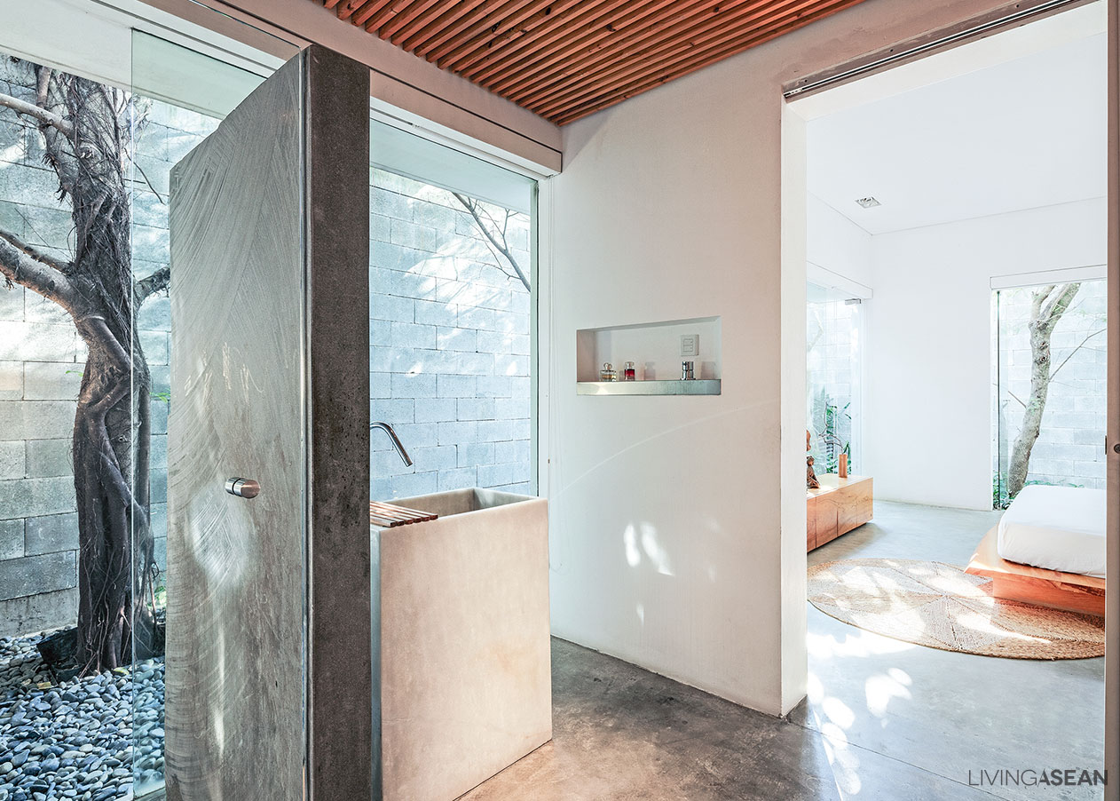 The bathroom is enclosed in clear glass for visual continuity with the rest of the private room.