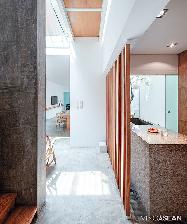 A slat wood panel effectively separates the kitchen from the corridor without disrupting air circulation in the interior.