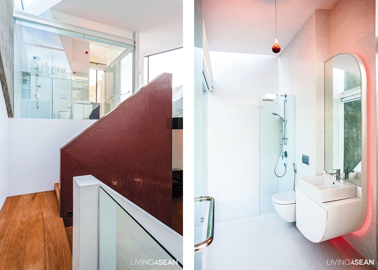 [Left] A bright and airy bathroom at the far end is visible from the stairway leading to the top deck. [Right] The bathroom in white comes with a wall-mounted countertop. The mirror with a rounded corner paired with soft pink recessed lighting creates a sense of spaciousness.