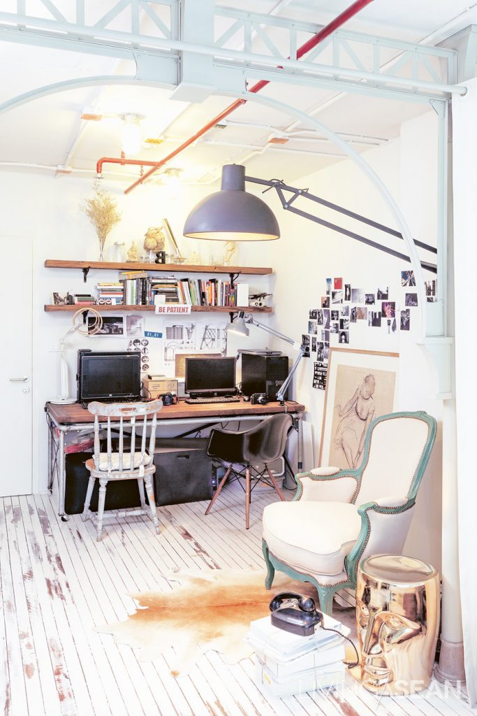 The work corner and the living room are in the same area. The desk consisted of metal legs made from water pipes and a wooden top to fit the width of the wall. Different cushions were originally placed here. But Priyawat later replaced them with his vintage armchair.