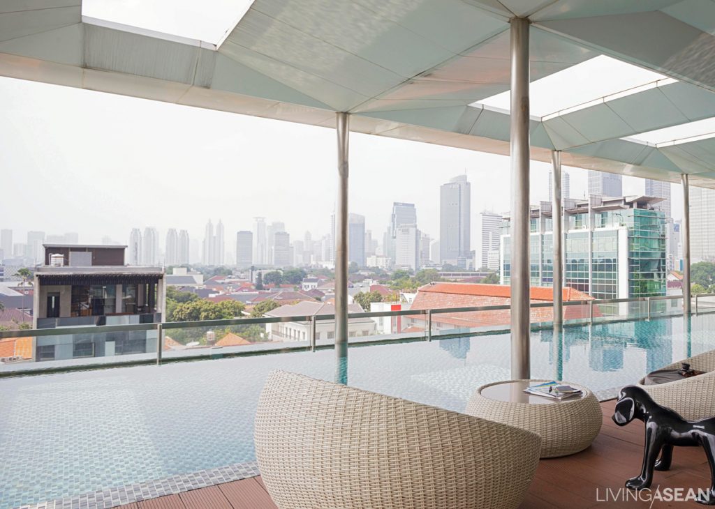 Cozy Resident's Lounge looks out over the lap pool with panoramic views of the city skyline stretching farther than the eye can see. 