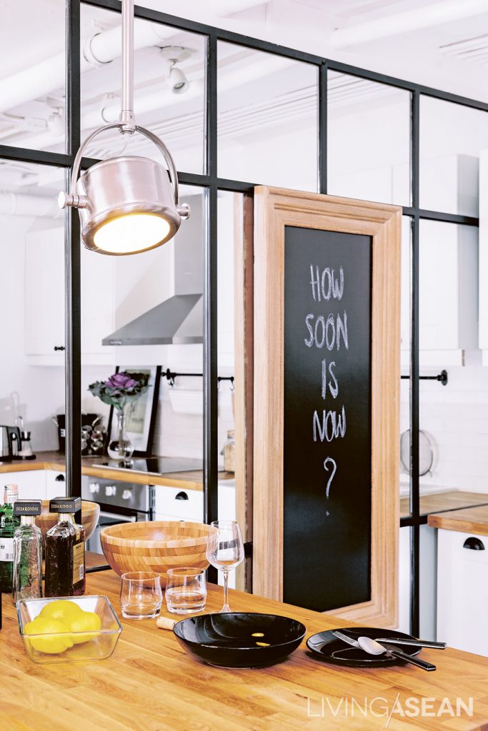A metal-framed mirror wall creates an illusion of a larger kitchen. 