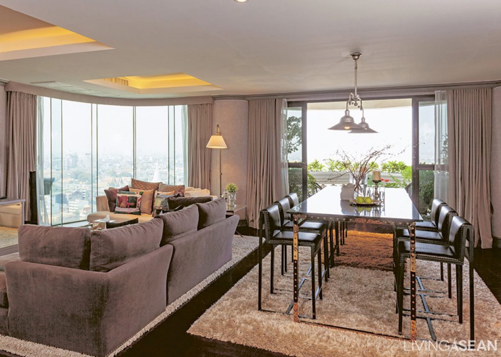The dining area next to the living area is a relaxing place to sit and look at the river through the panoramic curved glass. The plush gray carpet adds a sweet touch to soften any rigidity in the look of the table and dining area.