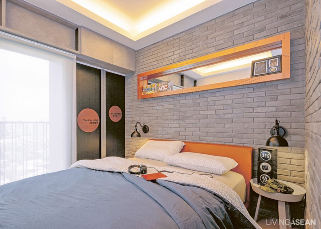  Bu’s bedroom offers a bit of underground chic with its stylized gray brick wall, reducing any seriousness implied by the brown leather bed upholstery. The shelf’s inner mirrors add an interesting dimension to the room. 