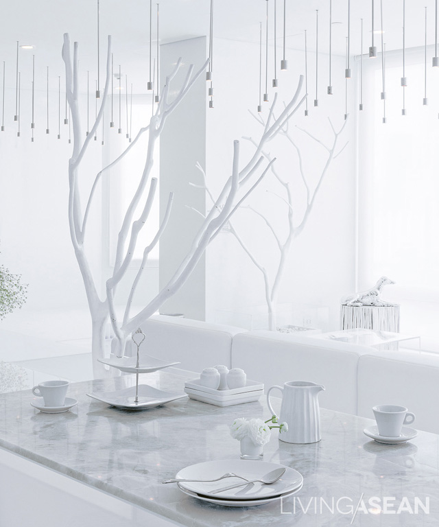 The dining table is topped with white marble, which is easy to clean. Decorative branches painted white give the sense of sitting under a tree. 