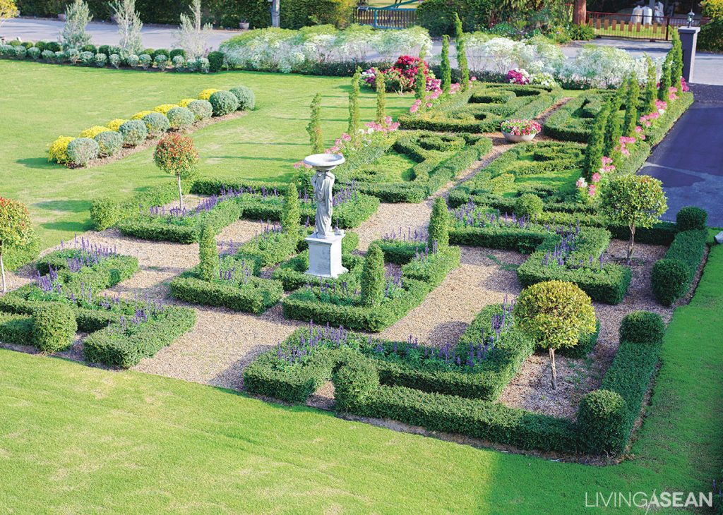 A symmetrical play of hedges and plant beds with squared or rounded frames are interspersed with sweet flowers that relieve any harshness. 