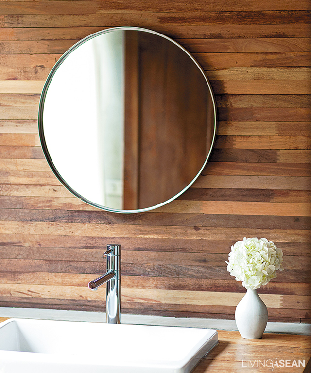Timber makes up the wood paneling wall in the bathroom opposite the bedroom. 