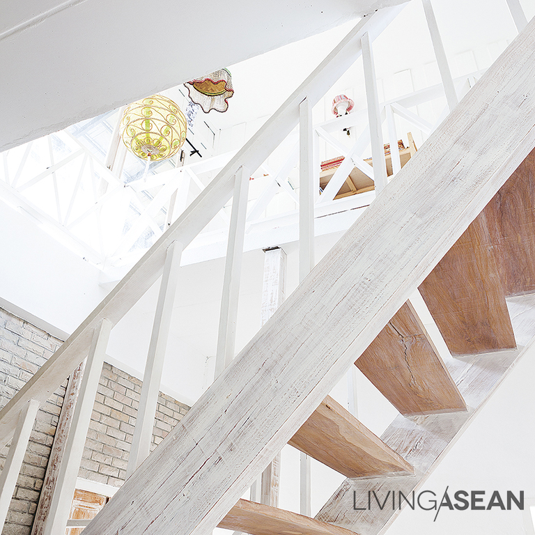 A vintage shade of white chalk on the staircase breaks the harsh appearance of dark colored wood.