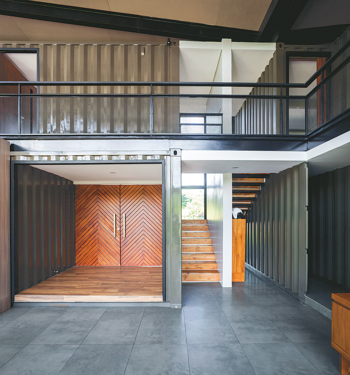 The front door divides the house left and right. Right is the office section, blocked off by a ridged container wall.