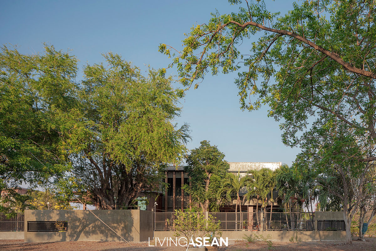 Seen from a distance, the house stands surrounded by mature trees that provide shade and make it comfortable to live.