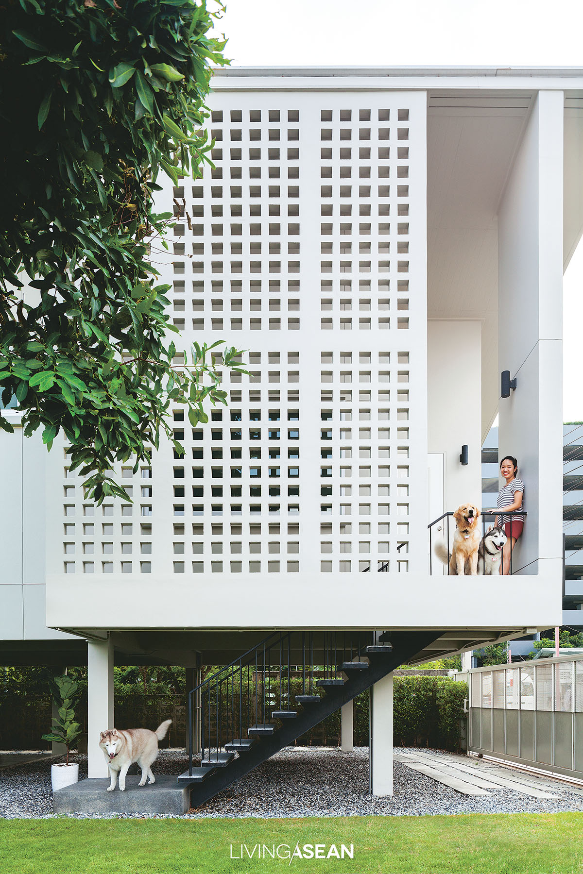 The side facing west gets double layer protection. While a rose apple tree keeps the house in shade during the day, a continuous vertical breeze block structure allows fresh air into the interior.