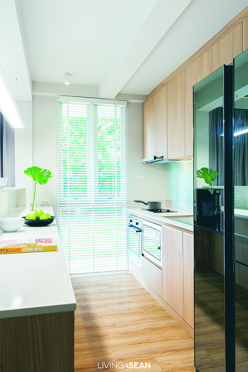 A counter for preparing food and drinks runs parallel to a pantry dedicated to storage. The open floor plan makes it easy to connect with nearby dining room and living room.